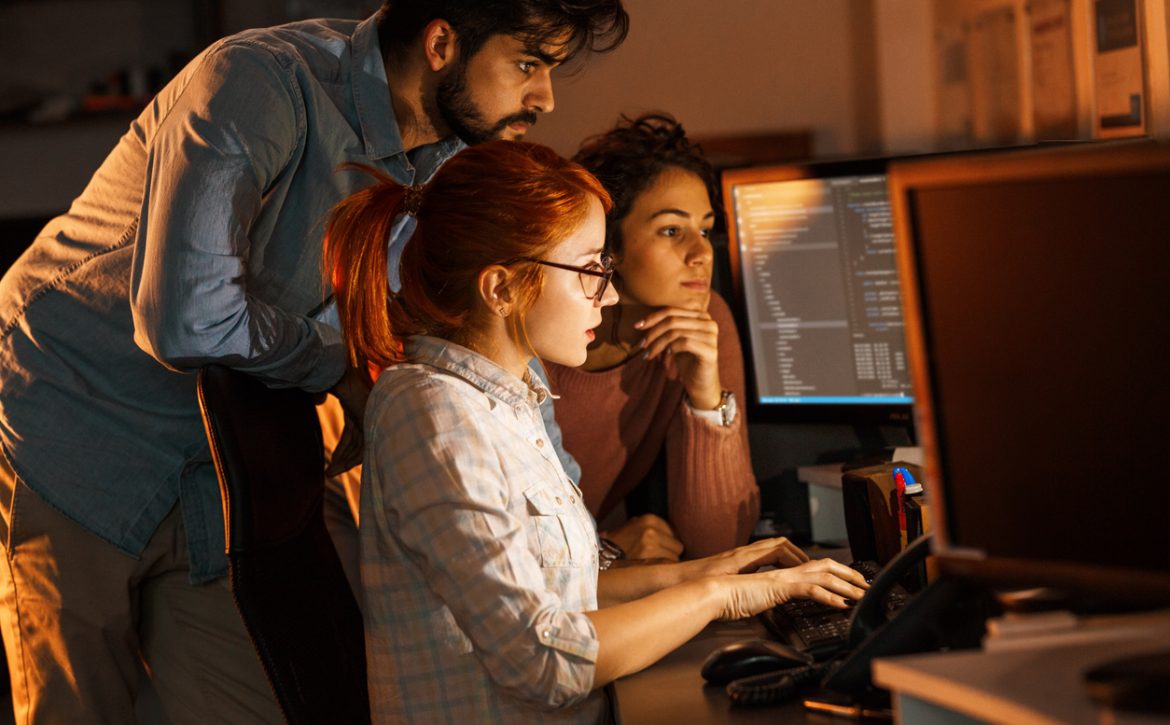 Team of programmers working on new project.They working late at night at the office.