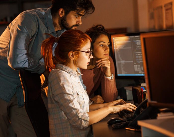 Team of programmers working on new project.They working late at night at the office.